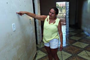 Jucilene Barros mostra a altura em que água chegou na casa / Foto: Evangelista Rocha