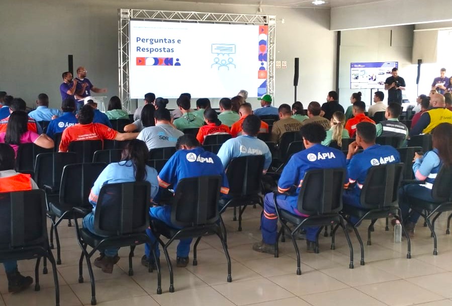Homem palestrando para uma audiência em um evento, com a tela exibindo 'Perguntas e Respostas'.
