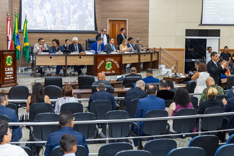 Sessão legislativa ou reunião da câmara em Marabá, PA, com autoridades em uma mesa e público em cadeiras.