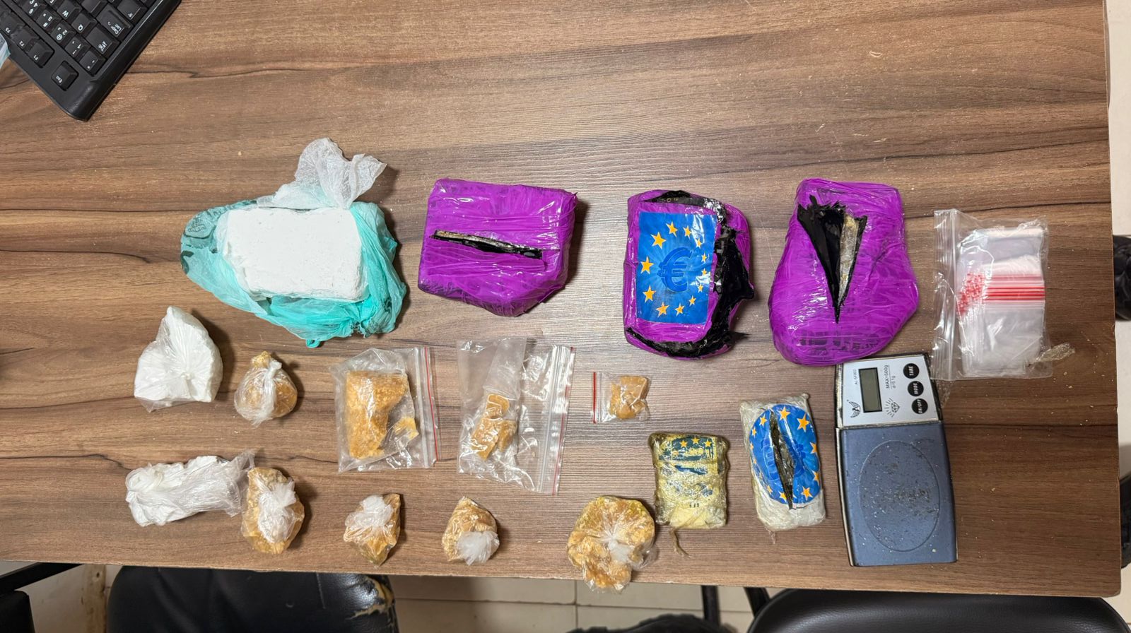 Apreensão de diversas drogas e entorpecentes em uma mesa de madeira.