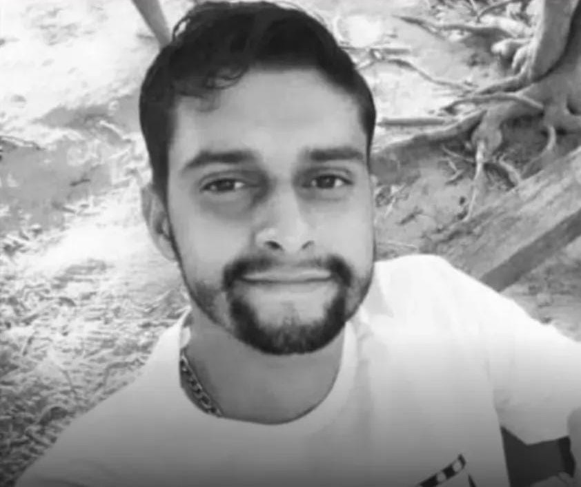 Homem sorrindo, fotografia em preto e branco.