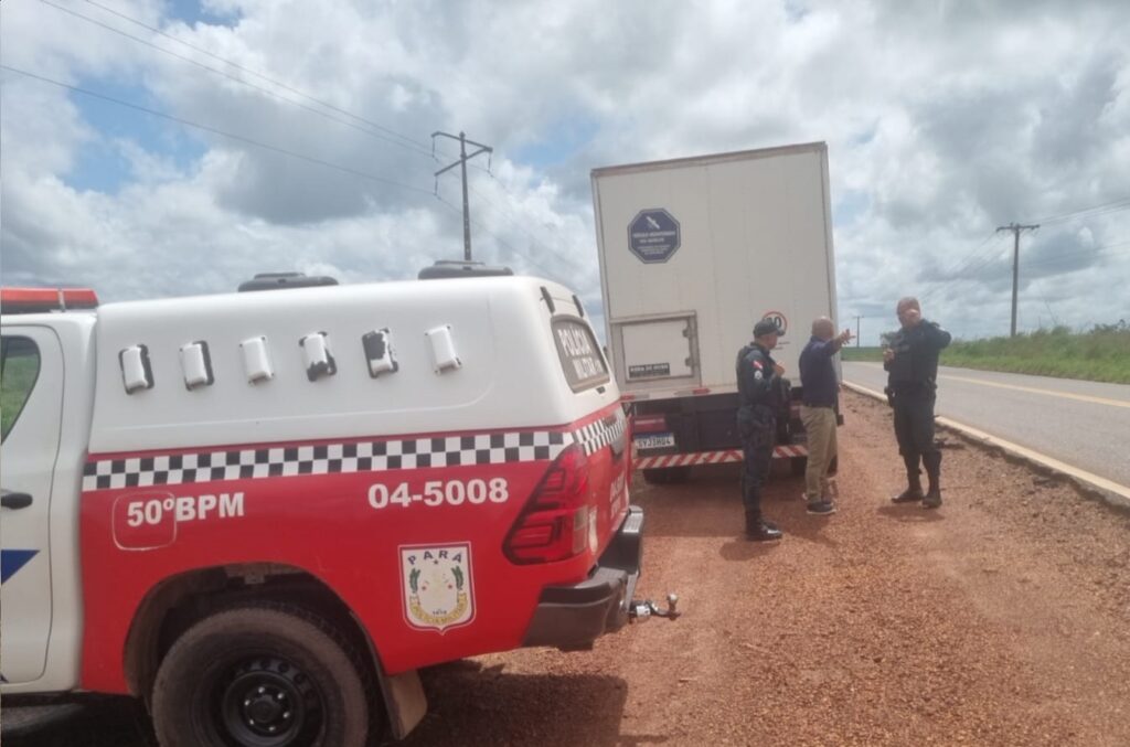 Viaturas da Polícia Militar do Pará e caminhão em fiscalização na estrada de terra.