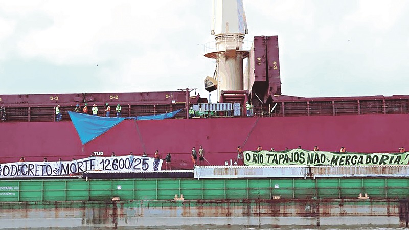 Protesto no Rio Tapajós com pessoas em balsa exibindo faixas contra decreto e pela defesa do rio.