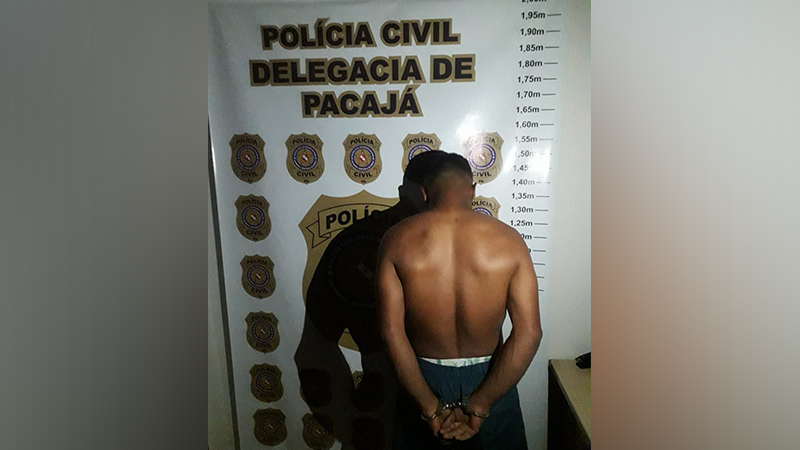 Homem algemado de costas em delegacia, com fundo da Polícia Civil de Pacajá e escala de altura.