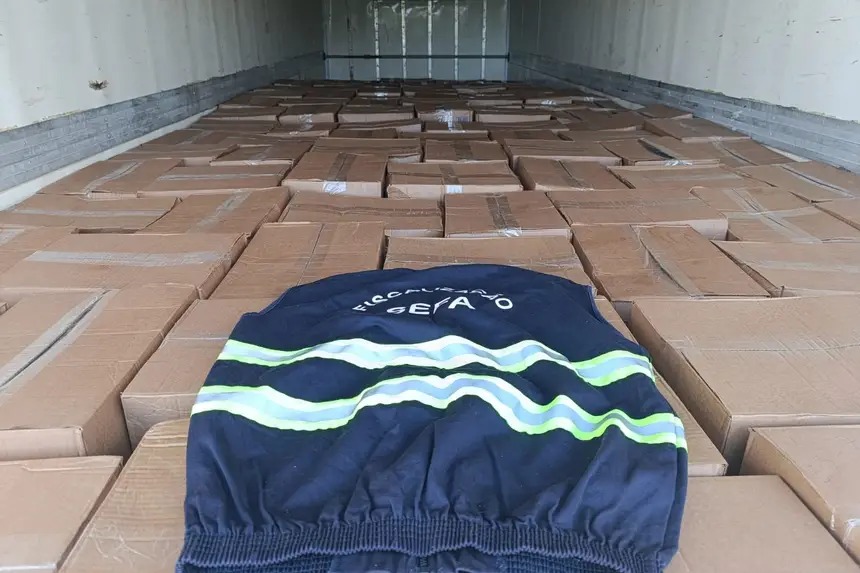 Interior de caminhão com caixas e colete de fiscalização.