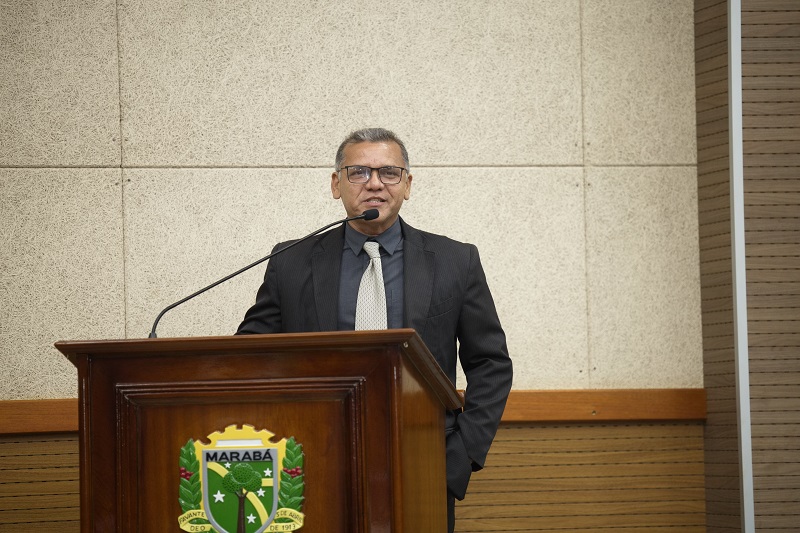 Homem de terno discursando em pódio com brasão de Marabá.