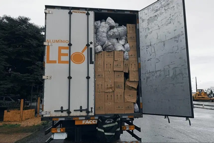Caminhão "ALUMÍNIO LEO" com portas abertas, exibindo carga de caixas e produtos de alumínio embalados.
