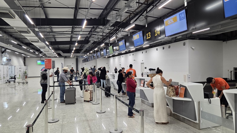 Passageiros fazendo check-in em balcões da GOL em aeroporto movimentado.