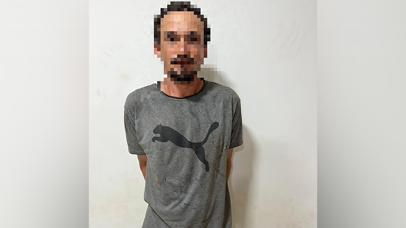 Homem com rosto pixelado usando camiseta cinza da Puma em frente a parede clara.