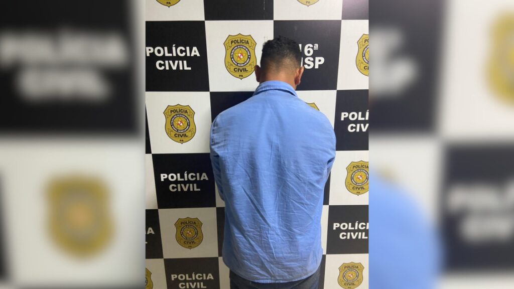 Homem de costas em delegacia com logo da Polícia Civil.