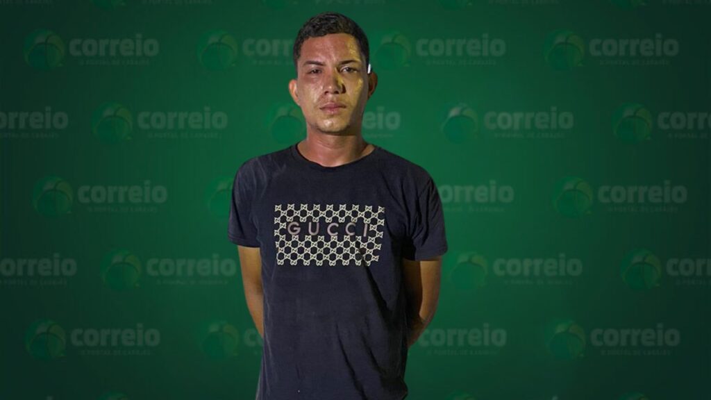 Homem de camiseta preta com logo Gucci em fundo verde do Correio.