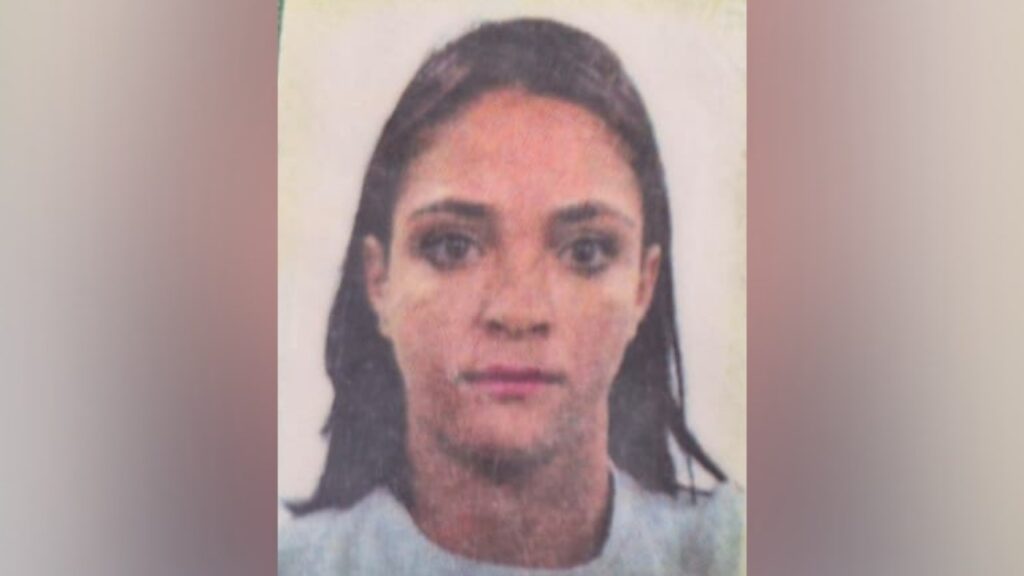 Foto de rosto de uma mulher com cabelos escuros e expressão neutra, em fundo claro.