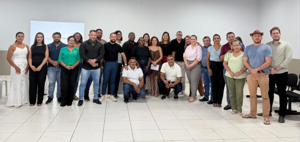 Um grupo diverso de pessoas posando para uma foto em um ambiente interno.