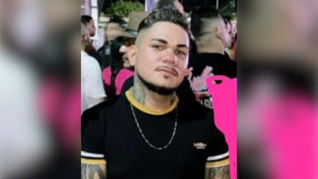 Retrato de homem com corte de cabelo moderno, barba e tatuagens no pescoço.