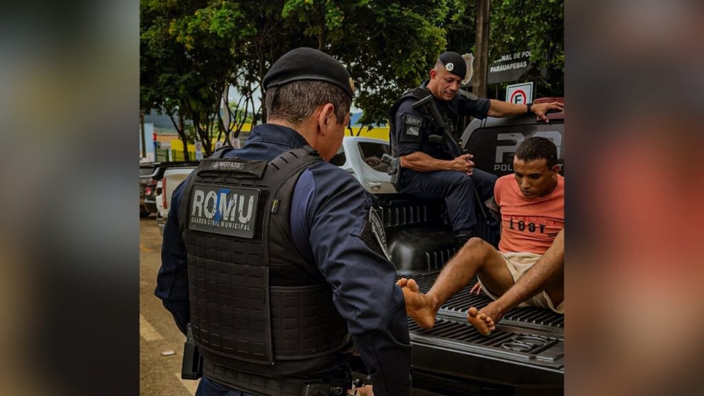 Guarda Civil Municipal ROMU e um homem detido no compartimento de carga de uma viatura policial.
