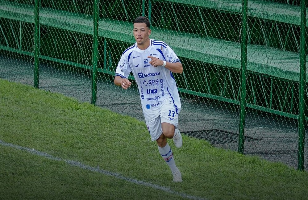 Jogador de futebol com camisa branca número 17 correndo em campo gramado.