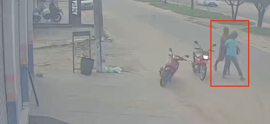 Imagem de rua com duas motos estacionadas, uma lixeira e a fachada de uma adega.