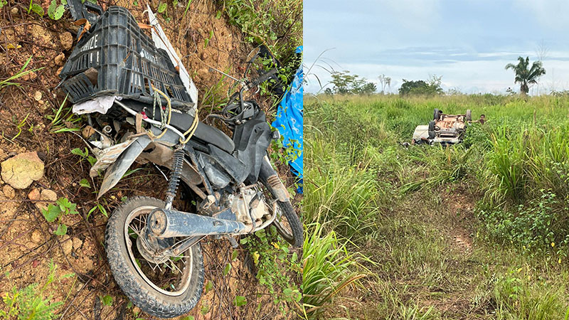 Motocicleta acidentada com caixa e veículo virado em campo.