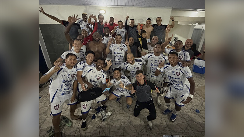 Time de futebol masculino celebrando em vestiário.
