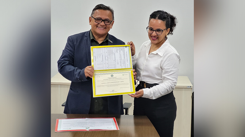 Homem e mulher sorrindo segurando um diploma da Universidade Federal do Pará.