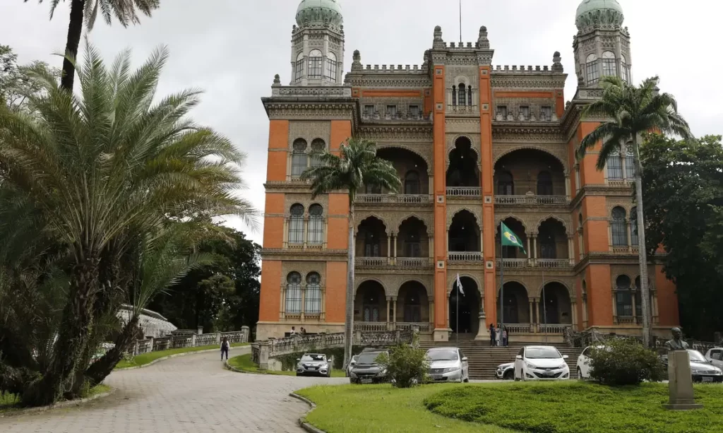 Palácio Rio Negro em Petrópolis, edifício histórico com arquitetura eclética e influência mourisca, cercado por palmeiras.