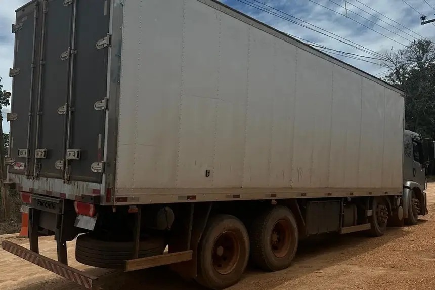 Caminhão-baú branco estacionado.