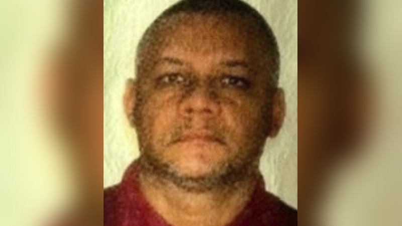 Homem de pele escura, cabelo curto, olhando para frente.