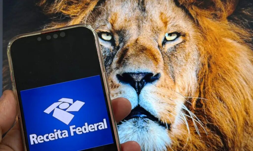 Smartphone exibindo o logo da Receita Federal à frente de uma imagem de leão.