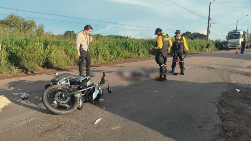 Acidente de moto na estrada com equipe de resgate e vítima no chão.