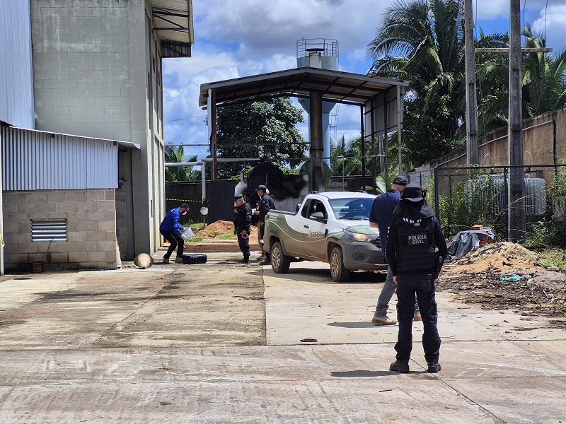 Oficiais da Polícia Civil em ação numa área industrial ou de armazenamento.