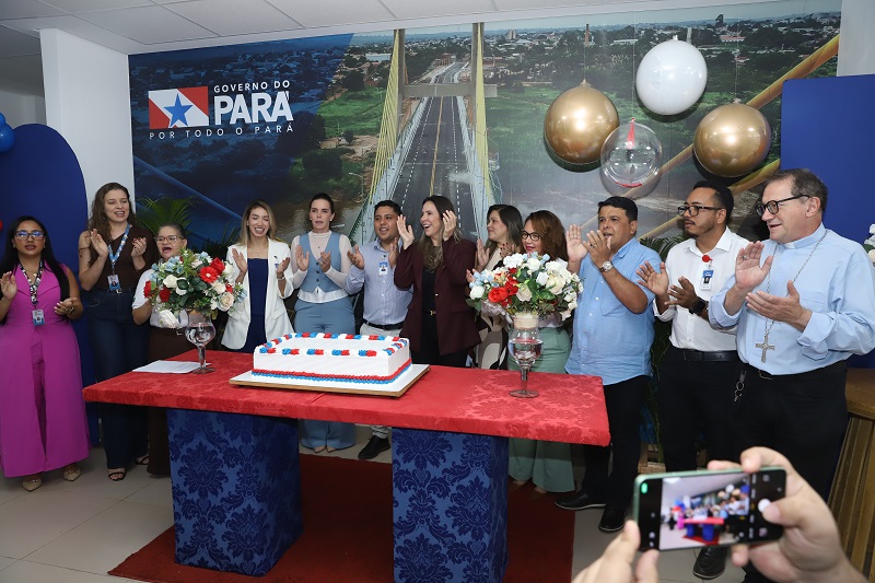 Grupo de pessoas aplaudindo em evento de celebração do Governo do Pará com bolo.