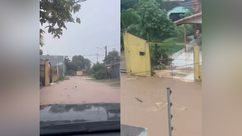 Rua residencial e portão de casa submersos em água barrenta de enchente.
