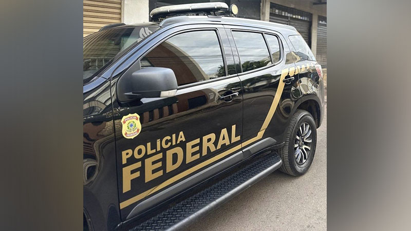 Viatura preta da Polícia Federal com logo dourado.
