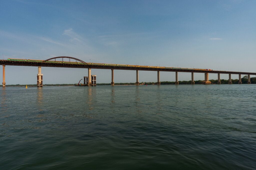 Ponte ferroviária sobre um rio com um trem de passageiros ou carga passando.