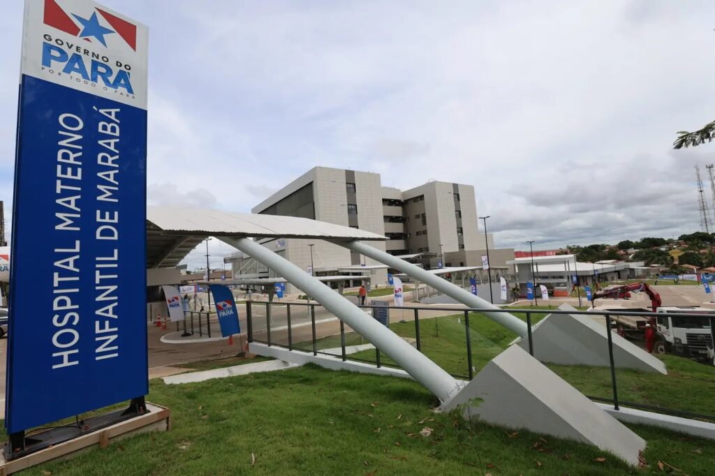 Fachada de hospital ou edifício institucional moderno com rampas de acesso cobertas, sinalização 'Pará' e gramado.