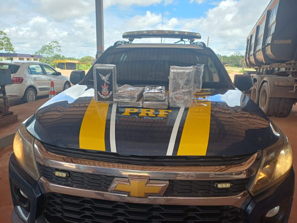 Viatura da PRF exibindo pacotes de entorpecentes apreendidos no capô.