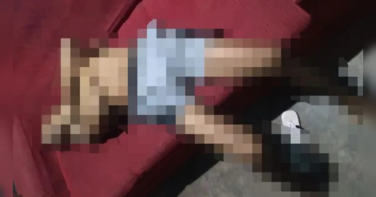 Imagem pixelada de uma pessoa deitada em um sofá vermelho.