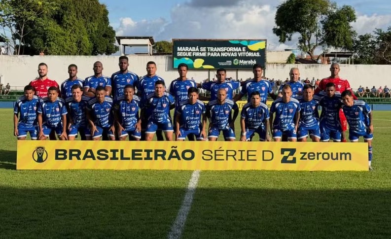 Time de futebol posando em campo com banner do Brasileirão Série D.