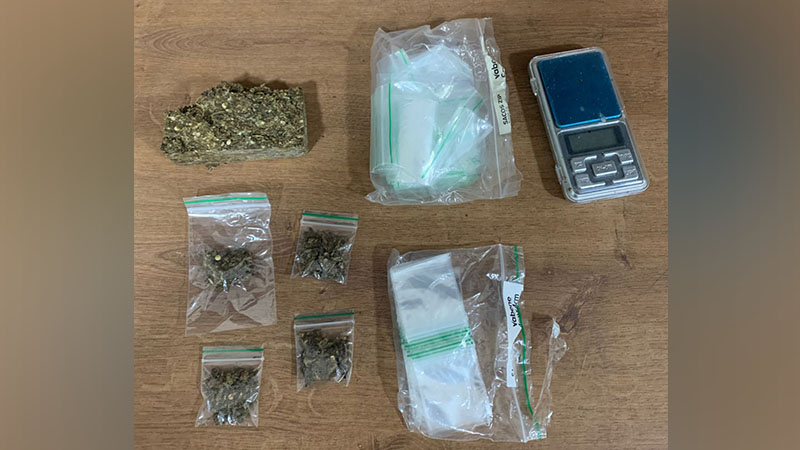 Drogas apreendidas e balança digital sobre uma superfície de madeira.