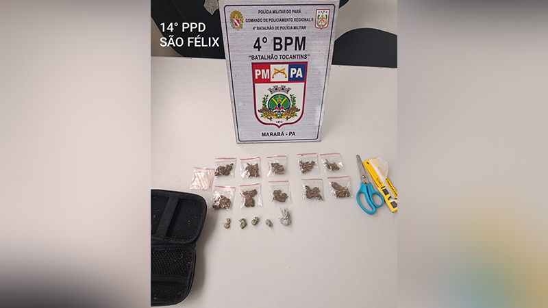 Exposição policial de drogas apreendidas e ferramentas em cima de uma mesa, com o distintivo da PM do Pará ao fundo.