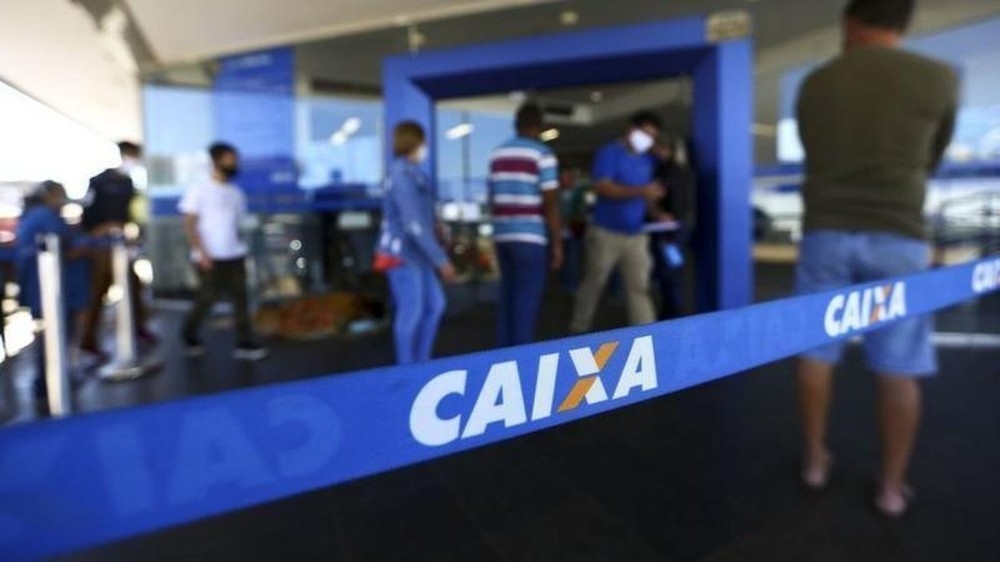 Fita azul da Caixa com pessoas entrando em agência bancária.