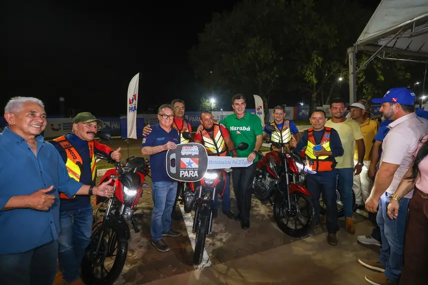 Grupo de homens com coletes refletivos e motocicletas vermelhas, um segurando uma chave gigante do 'Governo do Pará'.
