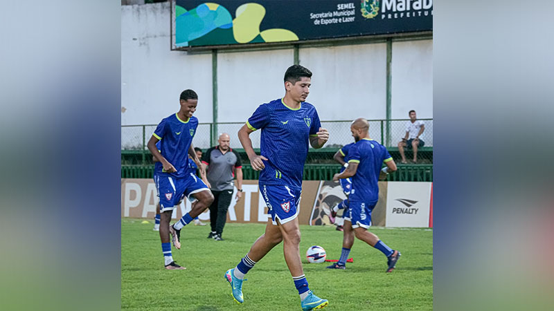 Jogadores de futebol em campo de grama durante uma sessão de treinamento.