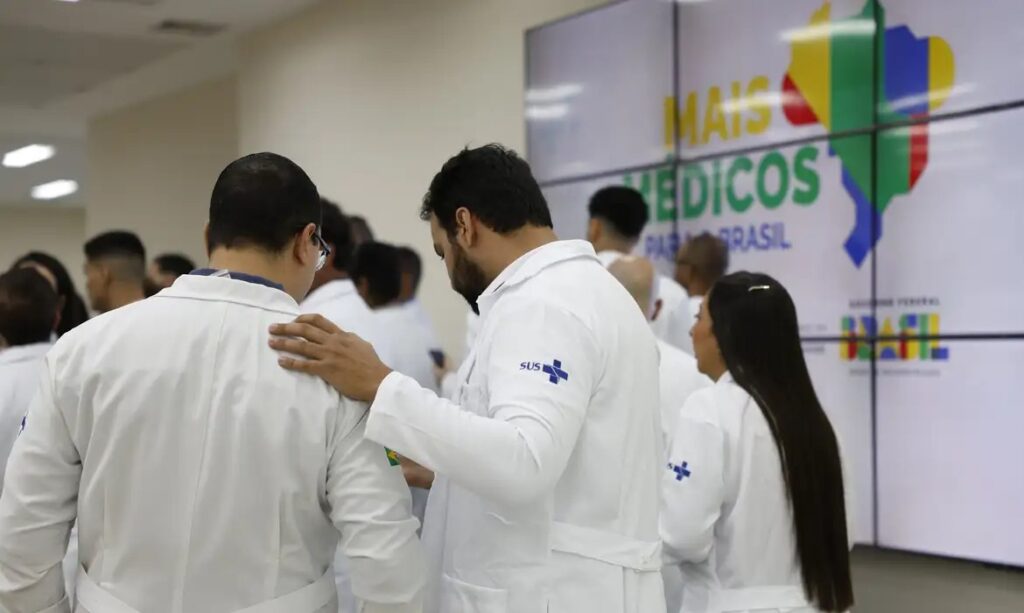 Grupo de médicos com jalecos brancos do SUS em evento do programa Mais Médicos.