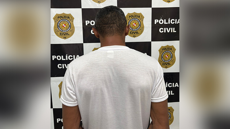 Homem de costas em frente a um painel da Polícia Civil do Pará.