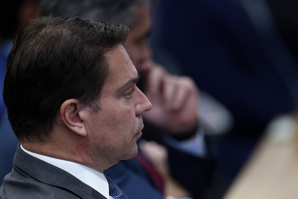 Homem em perfil, com terno e gravata, olhando para a direita.