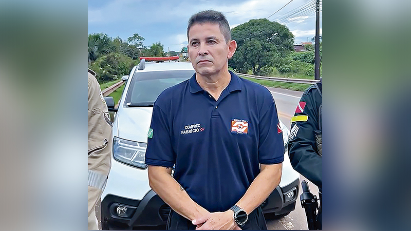 Homem em uniforme da Defesa Civil do Pará com viatura ao fundo.