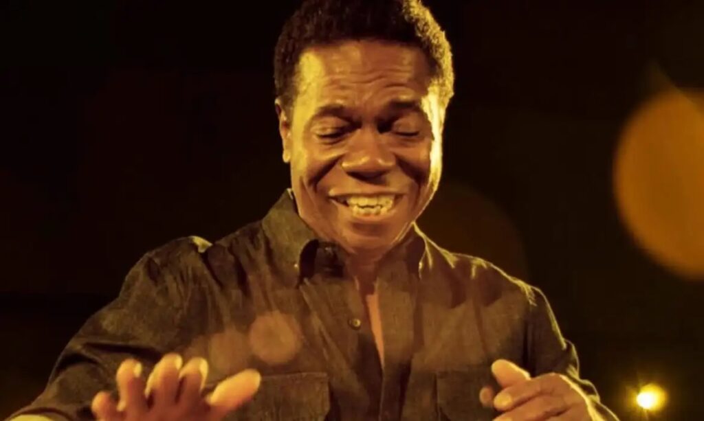 Homem sorrindo com os olhos fechados e expressão de alegria.