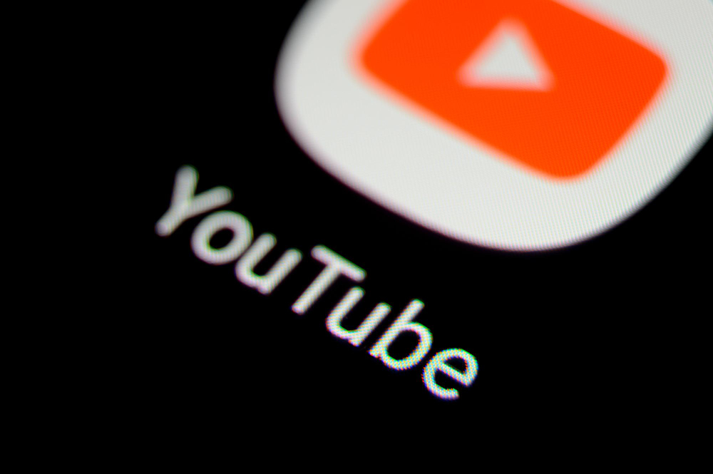 Logo e nome do YouTube em uma tela escura, com o ícone de reprodução vermelho e branco em destaque.