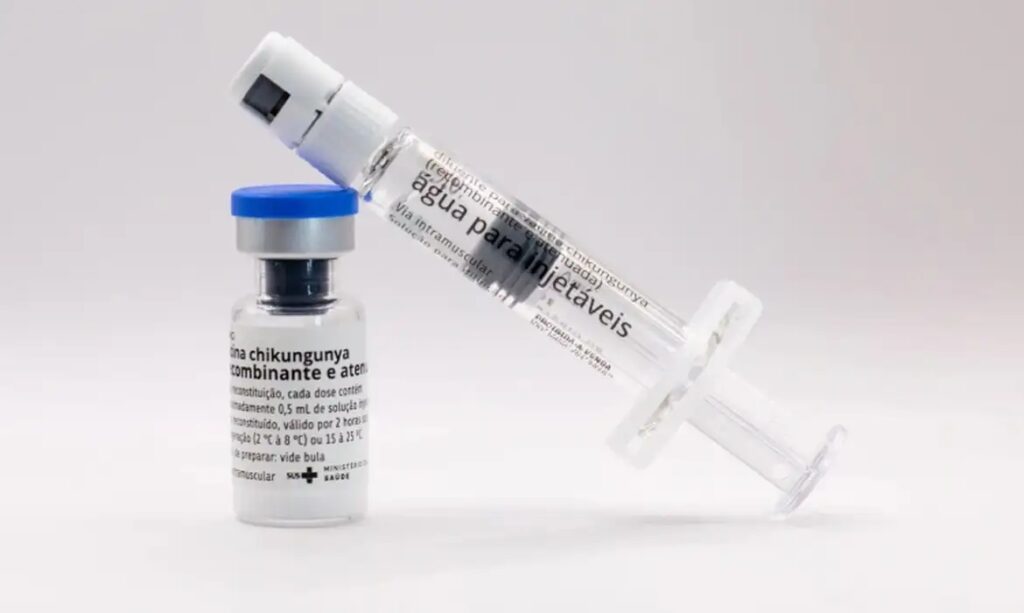 Frasco de vacina contra chikungunya com seringa de diluente ao lado.